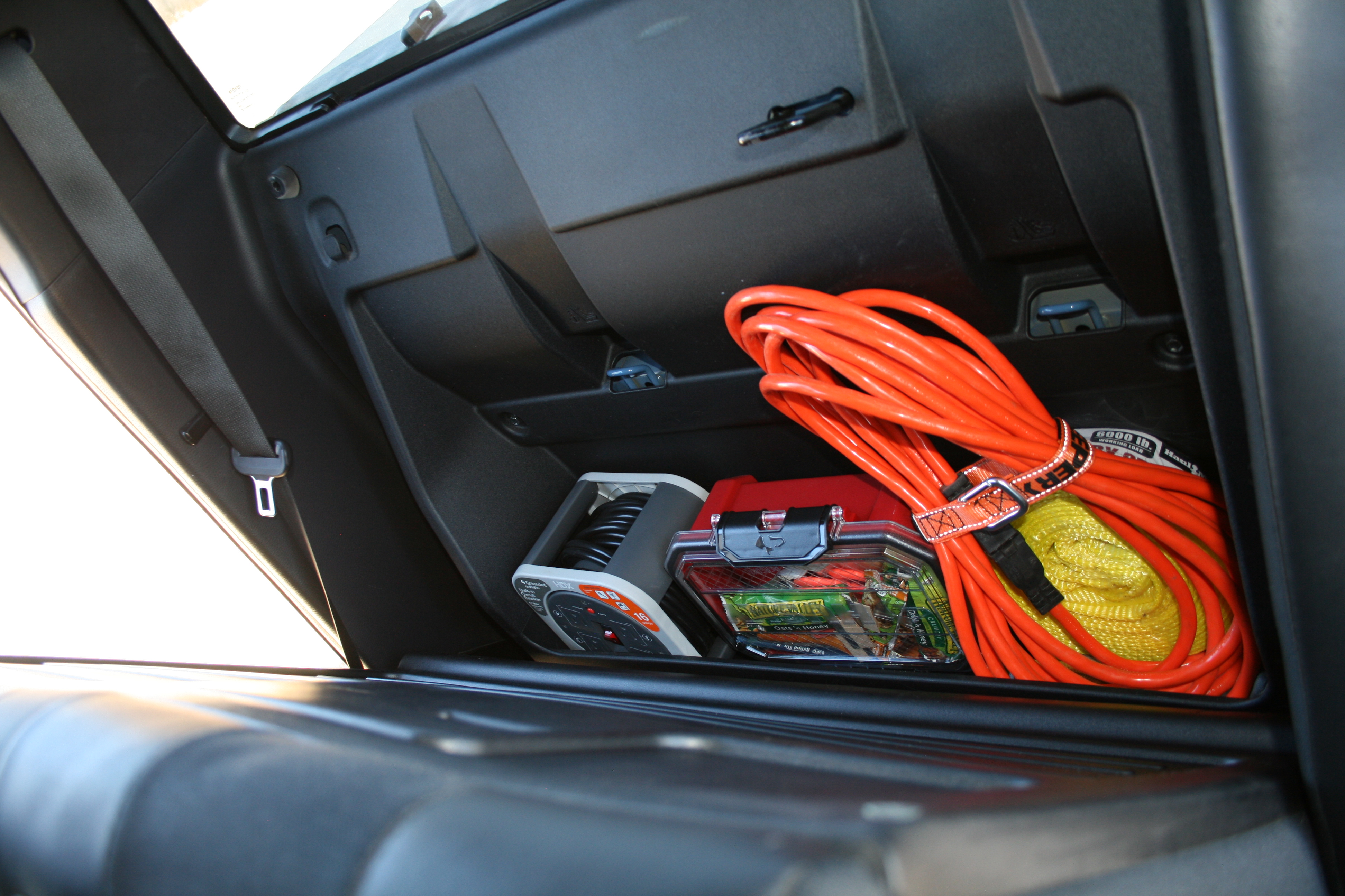 Tacoma TRD Pro behind passenger seat loaded with extension cord reel, snack case, and recovery strap
