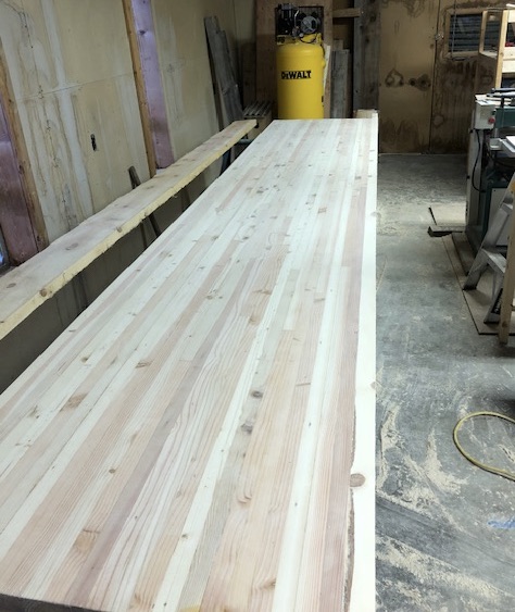 Ranch workbench assembled — laminated chicken coop timber top, beam legs, New Mexico shop