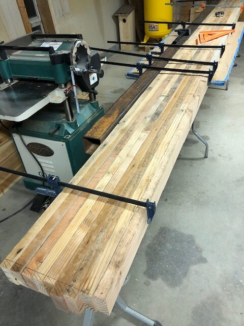Timber staged for planing — boards lined up beside the Grizzly G0453