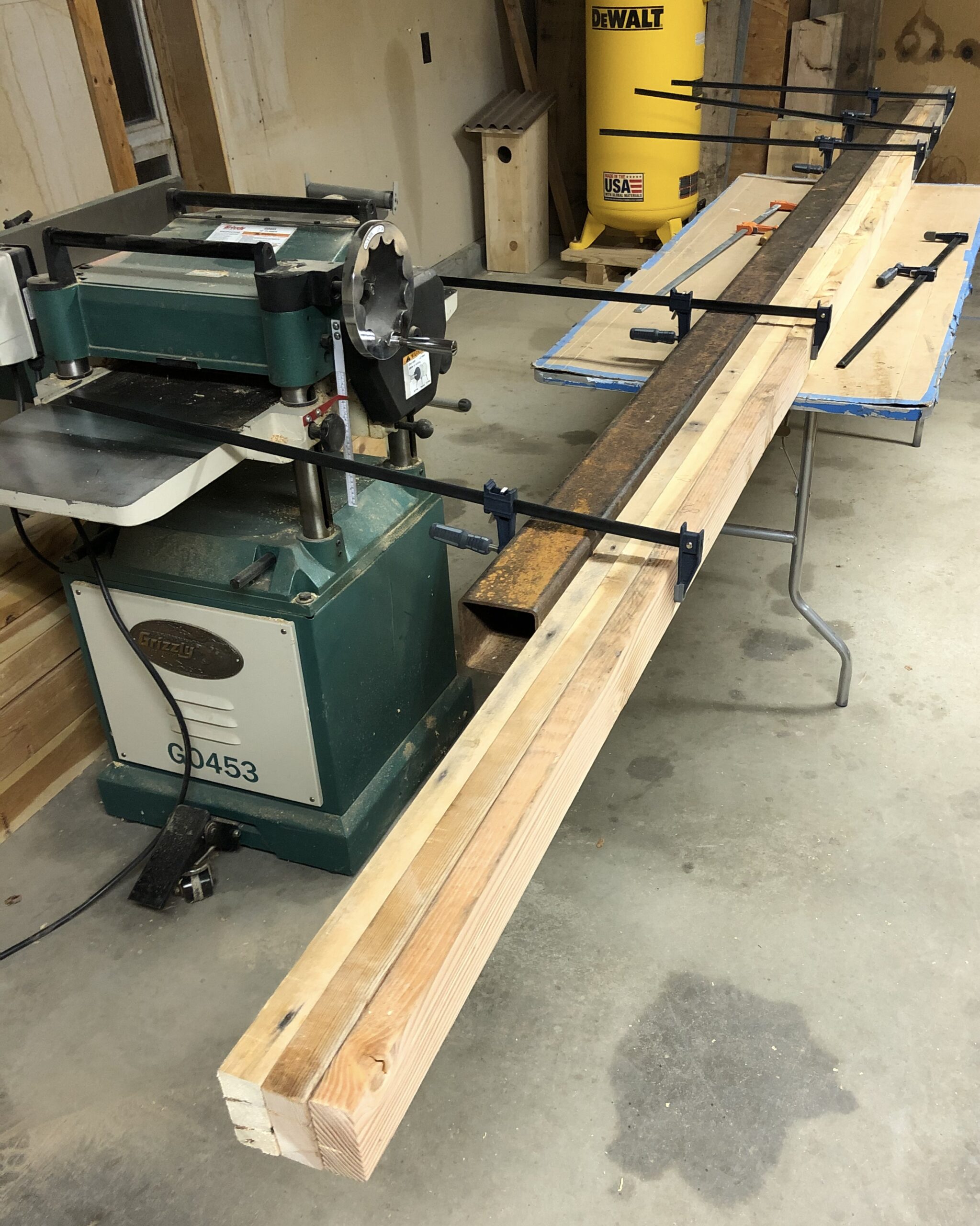 Salvaged chicken coop timber stacked and sorted — boards selected for the bench top