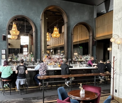 Death and Co Denver bar interior arched mirrors amber chandeliers teal walls