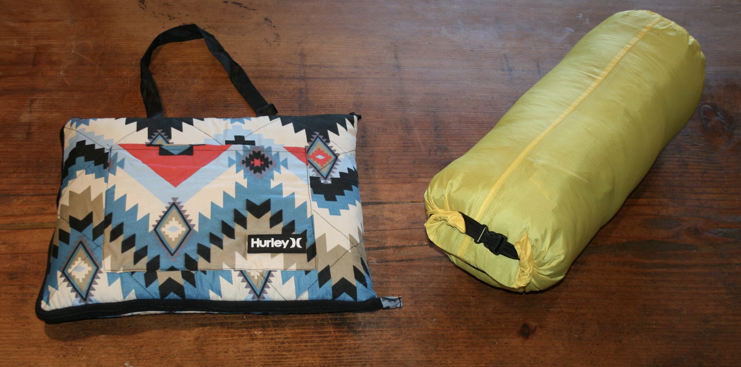 North Face 20F sleeping bag and Hurley blanket on wooden surface