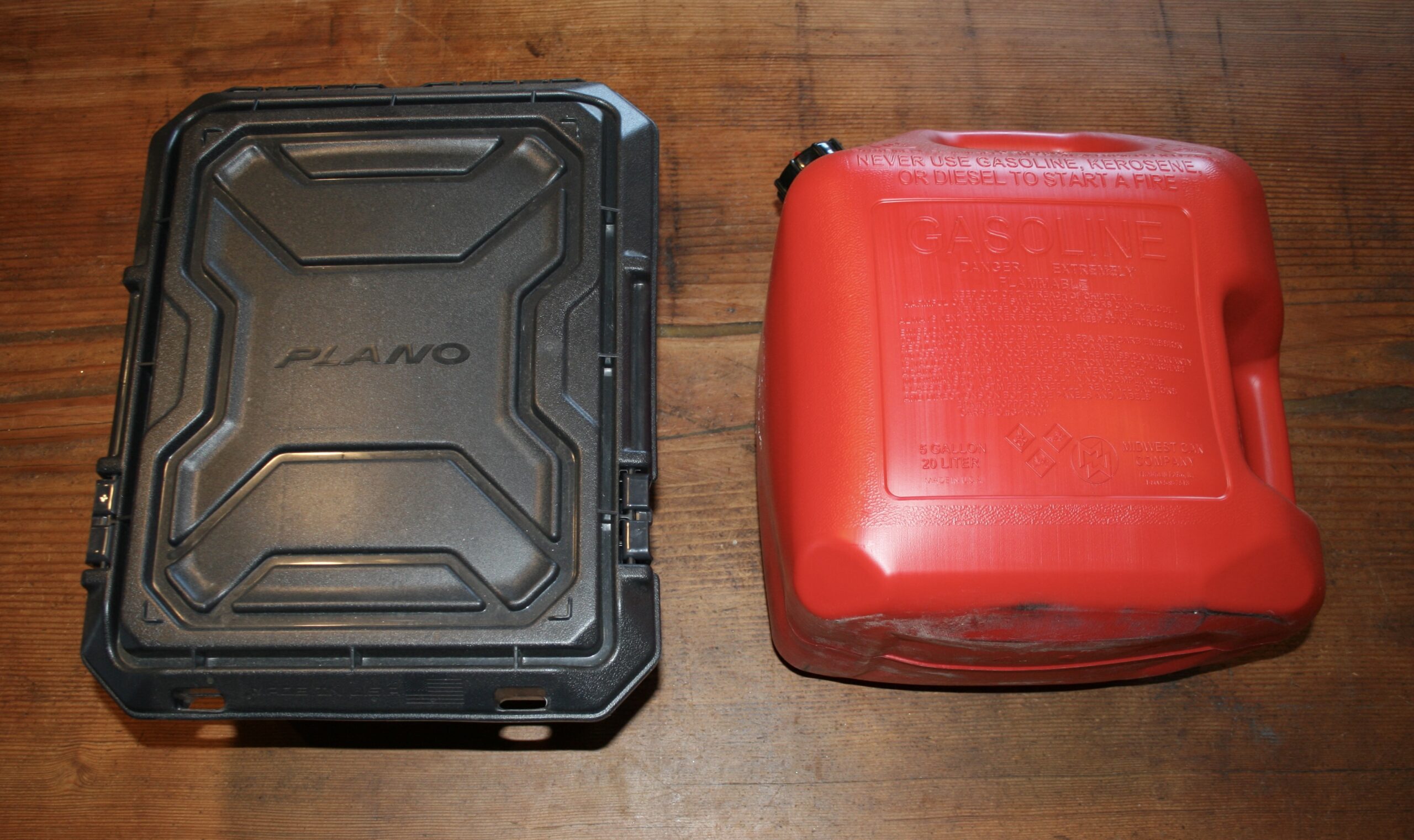 Plano lockable hard case and 5-gallon red gas can on wooden surface
